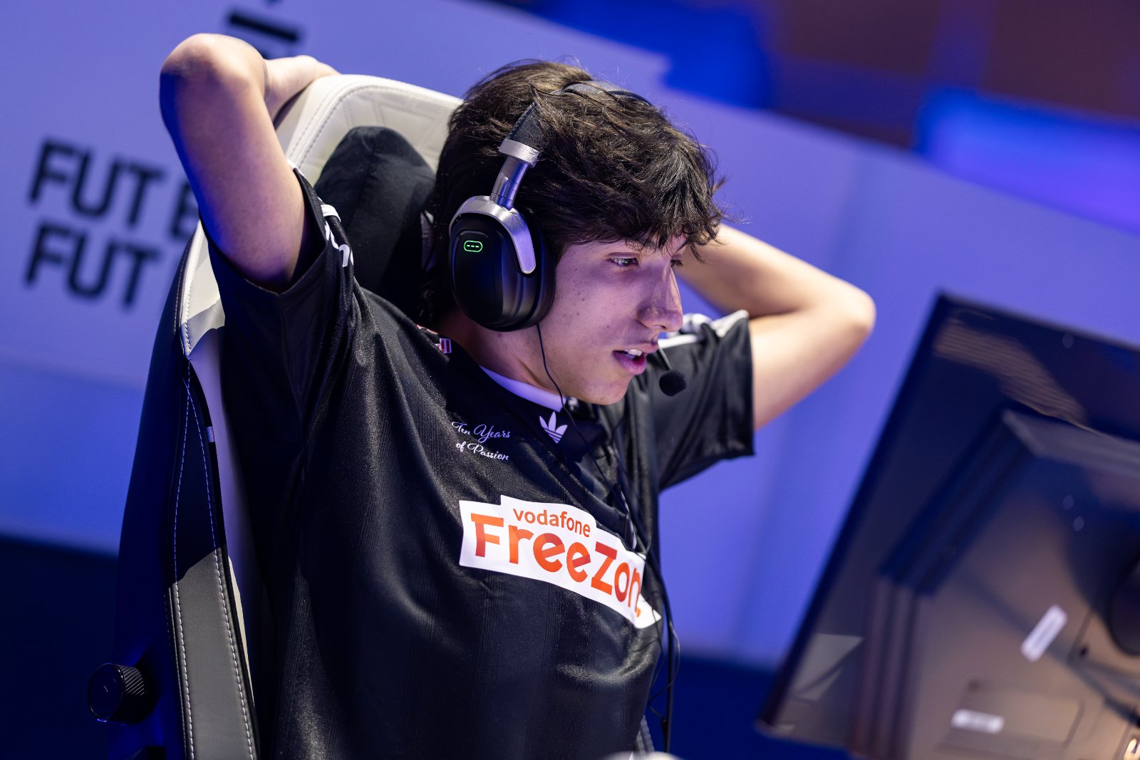 Fernando "Edson" Sobral em um campeonato de Fortnite, de headset e com as mãos atrás da cabeça