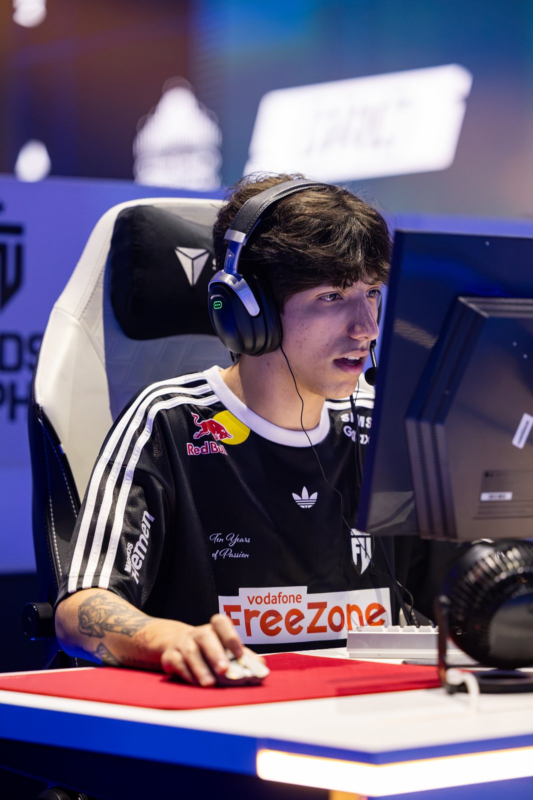 Edson jogando Fortnite em um campeonato presencial, de headset, concentrado no monitor